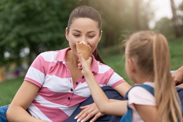 Sluit omhoog beeld van jonge gelukkige familie die hun weekend in park doorbrengen