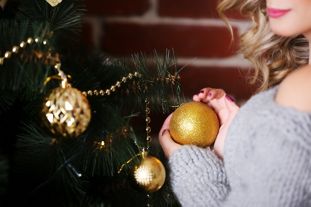 Sluit omhoog beeld van jonge vrouw die gouden Kerstmissnuisterij in handen houden