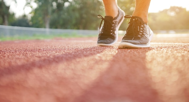 Sluit omhoog benen en loopschoenen van de sportmens