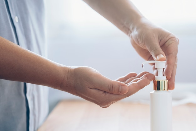 Sluit omhoog de mens gebruikend fles antibacterieel het ontsmettingsmiddelgel van de washand.