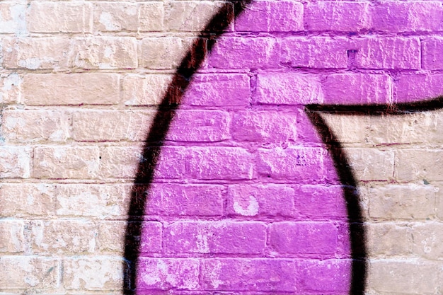 Sluit omhoog detail van geschilderde bakstenen muur met graffitistuk