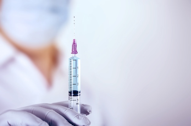 Sluit omhoog een medische injectiespuit ter beschikking van arts, medische wetenschapsconcept.