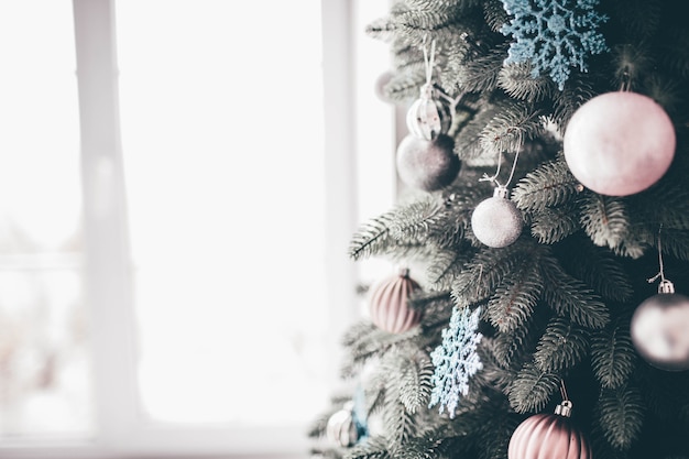 Sluit omhoog en knip de weergave van het versierde deel van de kerstboom klaar voor de tijd van het nieuwe jaar. Roze en witte versieringen rondom de boom.