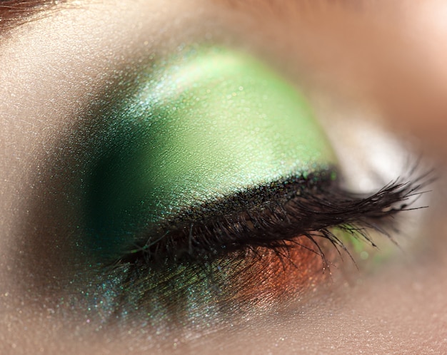 Sluit omhoog foto van gesloten vrouwenoog met groene make-up