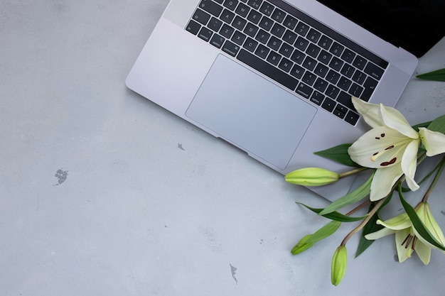 Sluit omhoog geopende laptop met bloem op oud houten bureau. Plat lag stijl