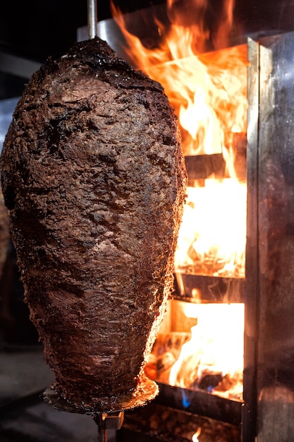 Sluit omhoog geschoten van het gestapelde vlees roosteren om als voorbereiding van traditionele Griekse schotelgyros of Turkse durum doner te worden gebruikt. shoarma