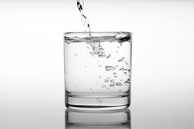 Sluit omhoog gietend drinkwater in glas
