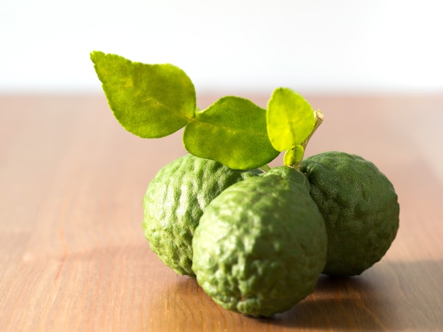 Sluit omhoog groep verse bergamot met groene bladeren op houten lijst.