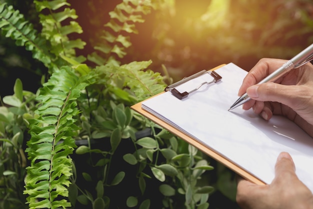 Sluit omhoog hand schrijvend op papier. Sluit mensen omhoog die op papier schrijven.