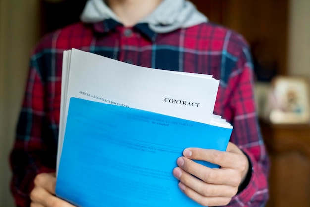 Sluit omhoog handen die blauwe document omslag houden met het contractblad f van documenten