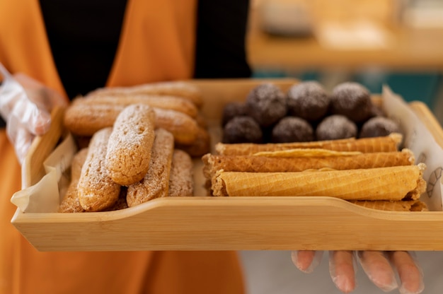 Sluit omhoog handen met dienblad met dessert