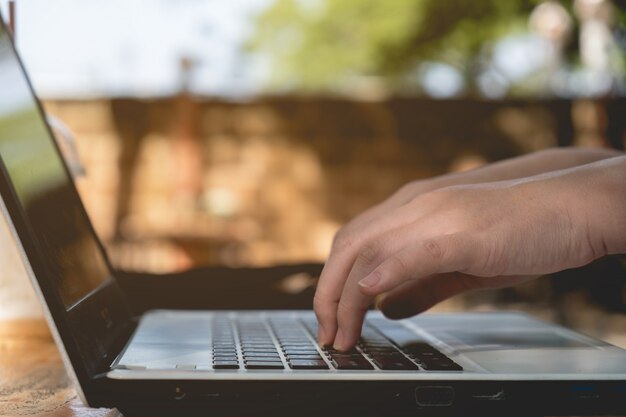 Sluit omhoog het typen van de Vrouw op laptop toetsenbord met zonneschijn, bedrijfs freelance concept
