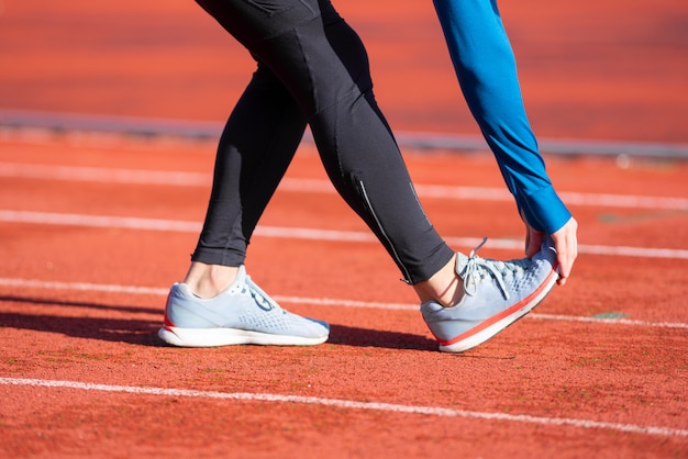 Sluit omhoog mening, atleet het uitrekken zich op een renbaan.