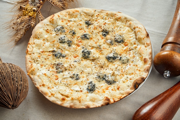Sluit omhoog mening over Smakelijke pizza 4 kaas met peer op een linnen grijs tafelkleed in een restaurant. Pizza in samenstelling. Italiaanse keuken. Plat eten