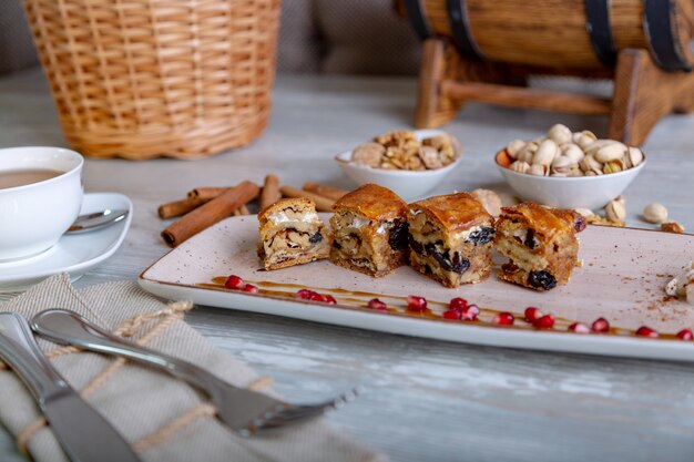 Sluit omhoog mening van mooie elegante oostelijke snoepjes, baklava, die op de plaat wordt gediend. mooie decoratie, restaurant gerecht, klaar om te eten. theetijd, gezellige sfeer.