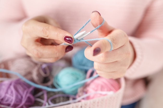 Sluit omhoog mening van vrouwelijke hand met clew kleur, breiend concept