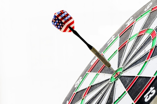 Sluit omhoog ontsproten van de pijltjepijl die op bulleyes van dartboard wordt geraakt. doel en doel als concept.