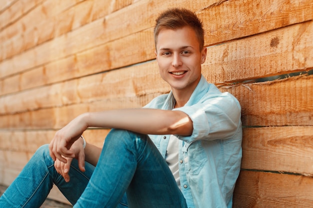 Sluit omhoog op jonge jongen dichtbij een houten muur