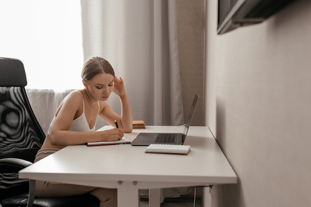 Sluit omhoog op mooie vrouw die met laptop werkt