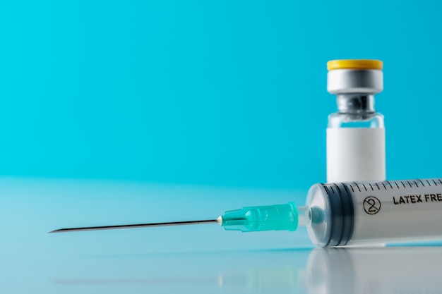 Sluit omhoog op vaccinserum in glasontvanger met een spuit