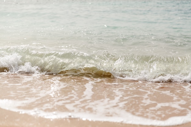 Sluit omhoog overzeese golven met plonsen op zandstrand. Detailopname