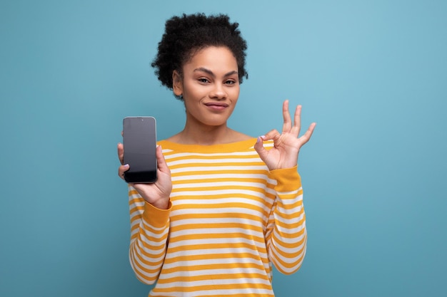 Sluit omhoog portret van de latijnse jonge vrouw van de mooie brunette met paardenstaart met mobiel telefoonmodel