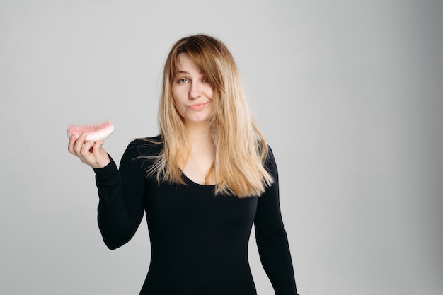 Sluit omhoog portret van jong verward meisje met slordig blonde haar