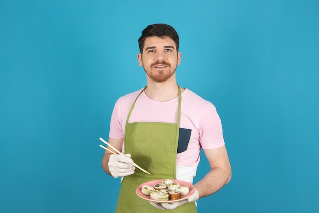 Sluit omhoog portret van jonge chef-kok die cakebroodjes houdt.