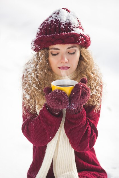 Sluit omhoog portret van jonge mooie vrouw met kop van hete koffie