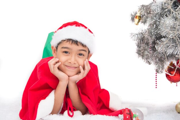 Sluit omhoog portret van weinig jongen die op de tijd van de kerstmisviering met het glimlachen glimlachen