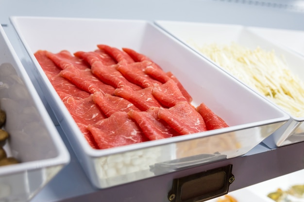 Sluit omhoog rundvlees binnen verse voedsellijn voor sukiyaki buffet in ijskast.