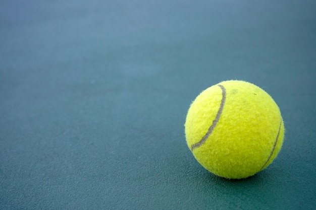 Sluit omhoog tennisbal op de hovenachtergrond.