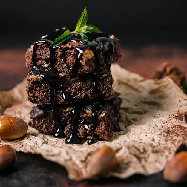 Sluit omhoog toren van chocoladenoot brownies met chocoladesiroop