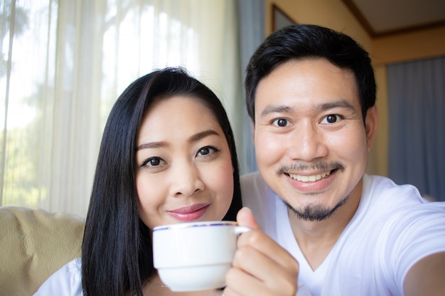 Sluit omhoog van Aziatische paarminnaar drinken hete koffie.