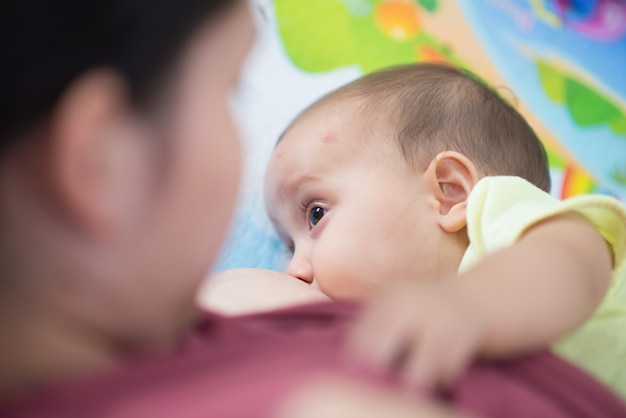 Sluit omhoog van babymeisje zogend haar mothere borst die - leggende kant bepalen