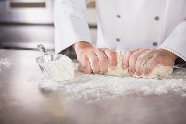 Sluit omhoog van bakker die deeg voorbereidt