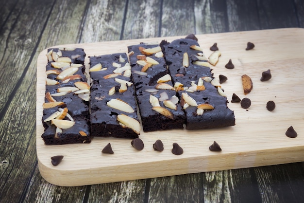 Sluit omhoog van cakecake brownies met noten op houten plaatachtergrond