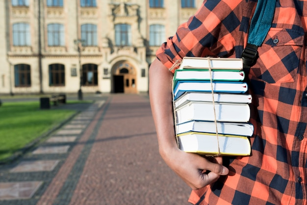 Sluit omhoog van de boeken van de tienerholding onder zijn wapen