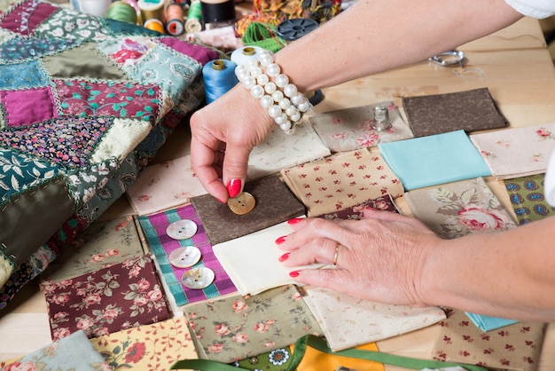 Sluit omhoog van de hand naaiend lapwerk van de vrouw