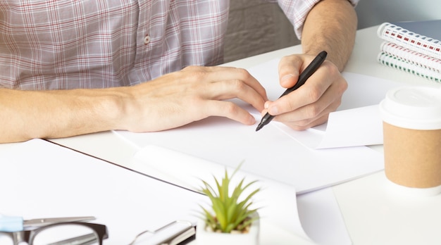 Sluit omhoog van de handen van de vrouw die in spiraalvormige blocnote schrijven die op houten Desktop met diverse punten wordt geplaatst