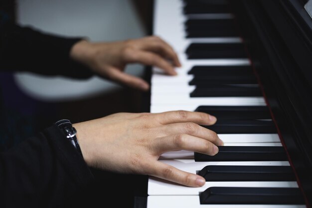 Sluit omhoog van de handen van de vrouw die piano spelen door bladmuziek te lezen. Selectieve focus