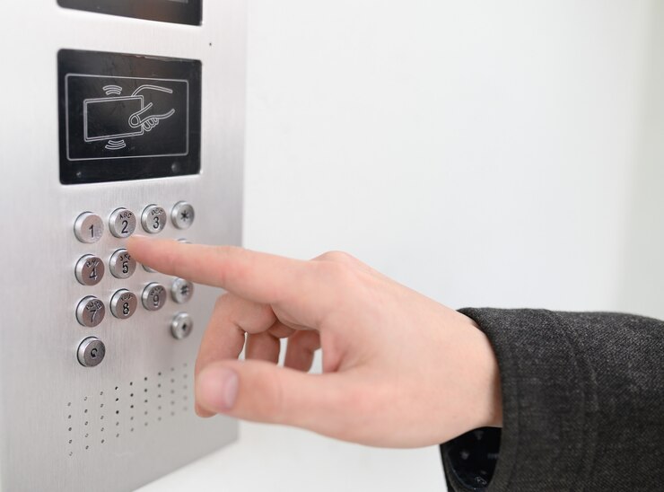 Sluit omhoog van de mens gebruikend intercom bij woningbouwingang