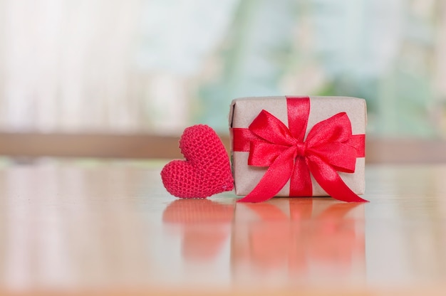 Sluit omhoog van de rode doos van de hart met de hand gemaakte en handcraft gift met rood lint voor de dagachtergrond van Valentine