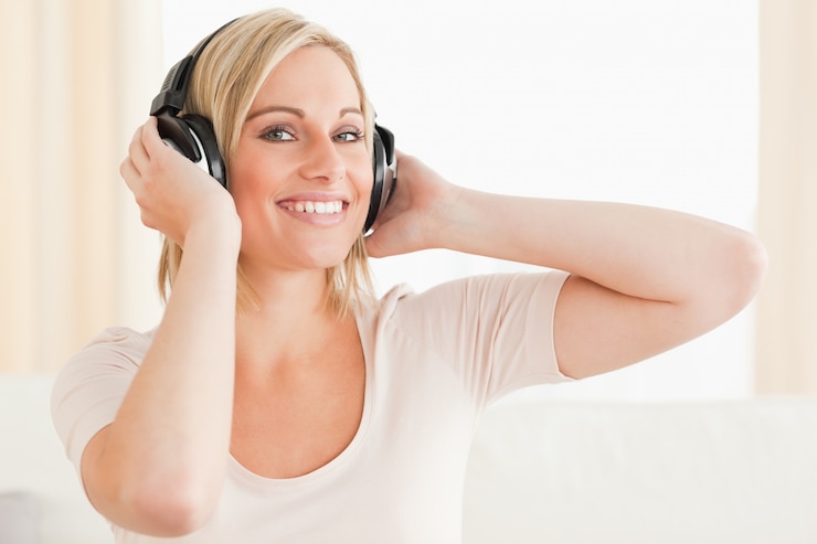 Foto sluit omhoog van een leuke vrouw die van wat muziek geniet