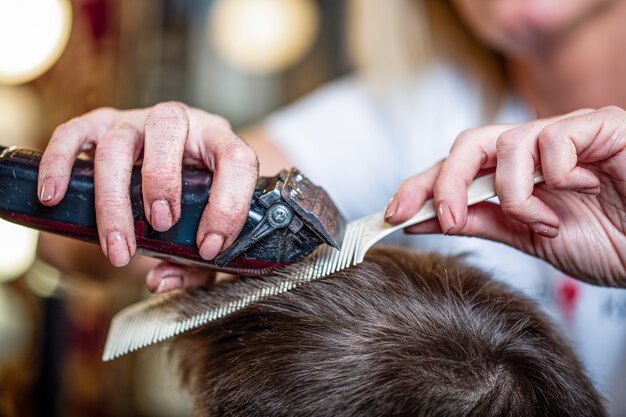 Sluit omhoog van een mannelijke student die een kapsel met haarclippers heeft