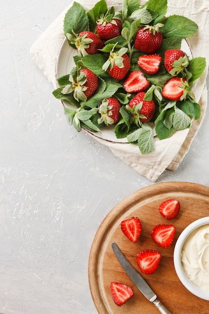 Sluit omhoog van een plaat met verse munt en sappige aardbeien.