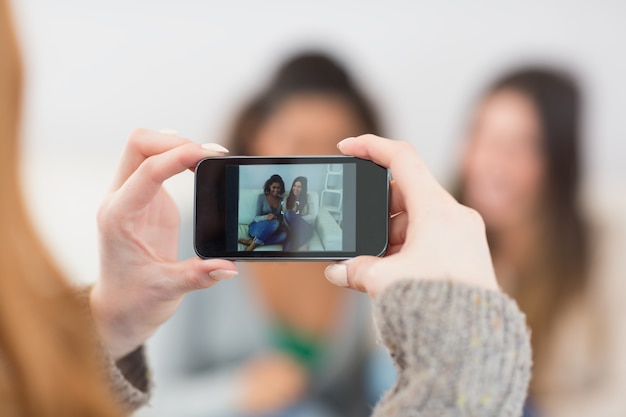 Sluit omhoog van een vrouw die vrienden met smartphone fotograferen