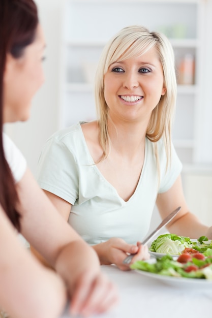 Sluit omhoog van glimlachende vrouwen die salade eten