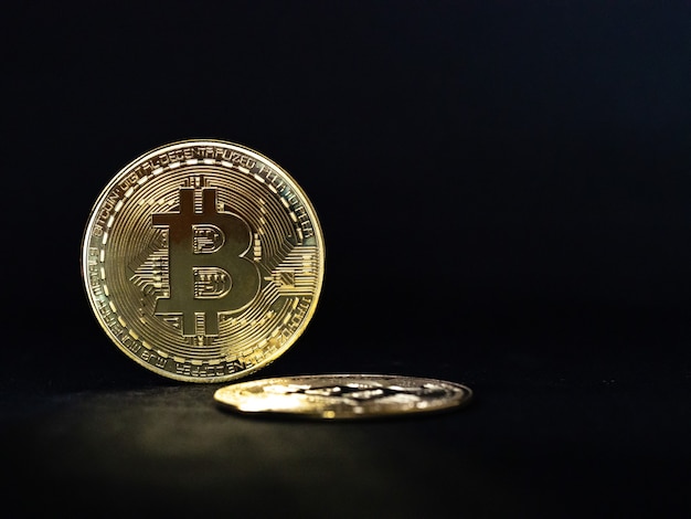 Sluit omhoog van gouden bitcoin op zwarte achtergrond met selectieve nadruk