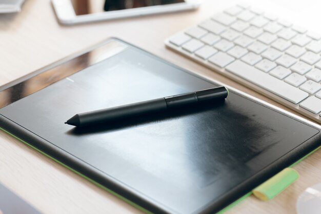 Sluit omhoog van grafische tablet met pen voor illustrators en ontwerpers in een bureau